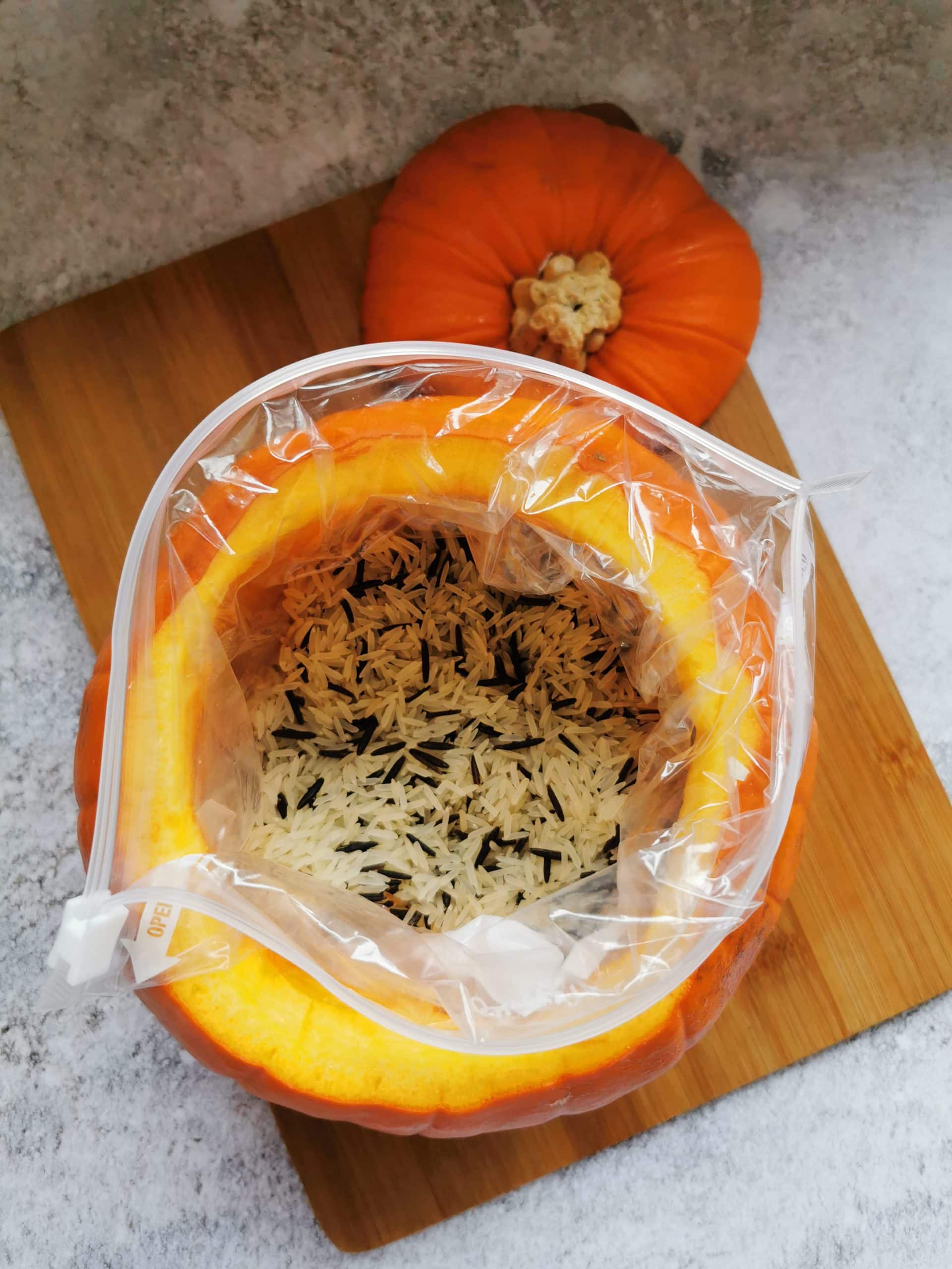 A pumpkin filled with rice in a plastic bag