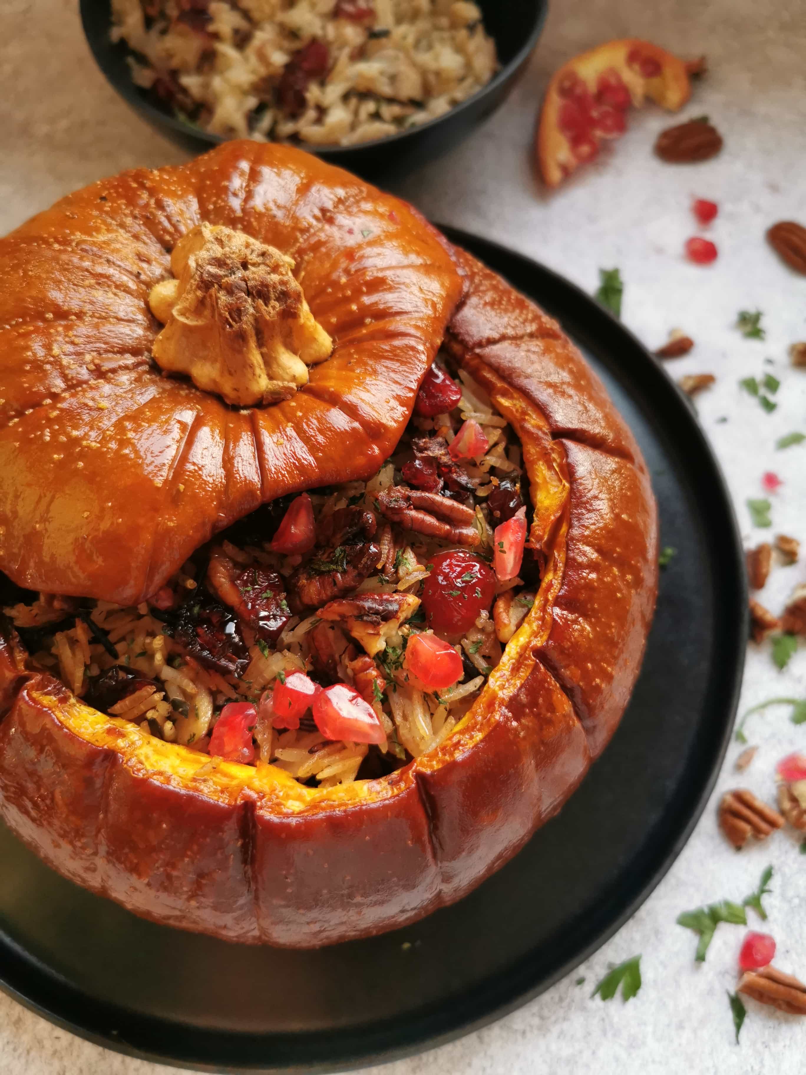 A stuffed pumpkin filled with rice, mushrooms, cranberries, herbs and topped with pomegranate seeds.