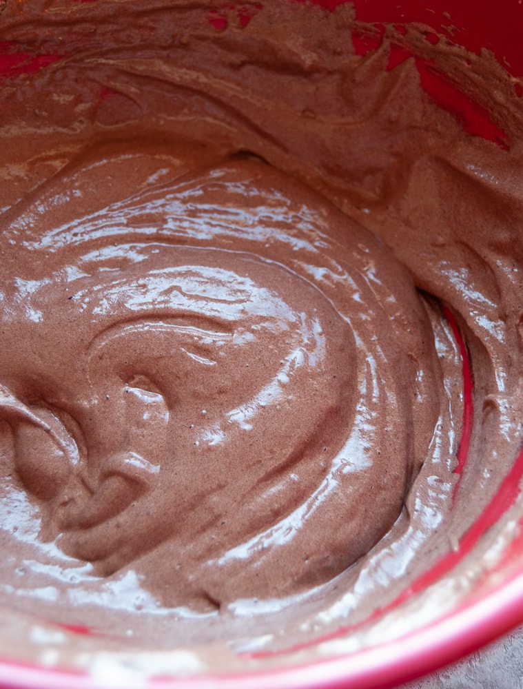 a chocolate cake batter in a red mixing bowl.