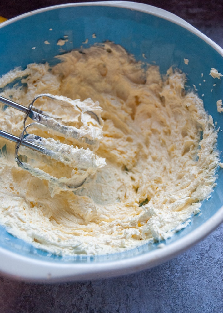 A bowl of creamed butter and sugar with an electric hand whisk