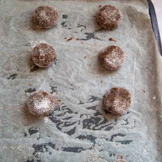 A tray of unbaked ginger cookies sprinkled with sugar