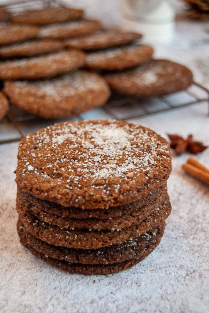 A stack of ginger cookies sprinkled with sugar on a grey and white background.