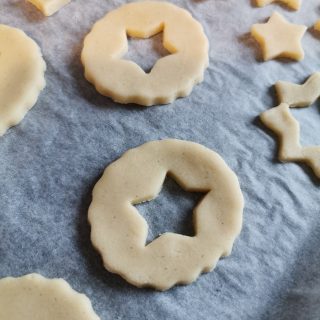unbaked Linzer cookies with star cut outs on a baking tray