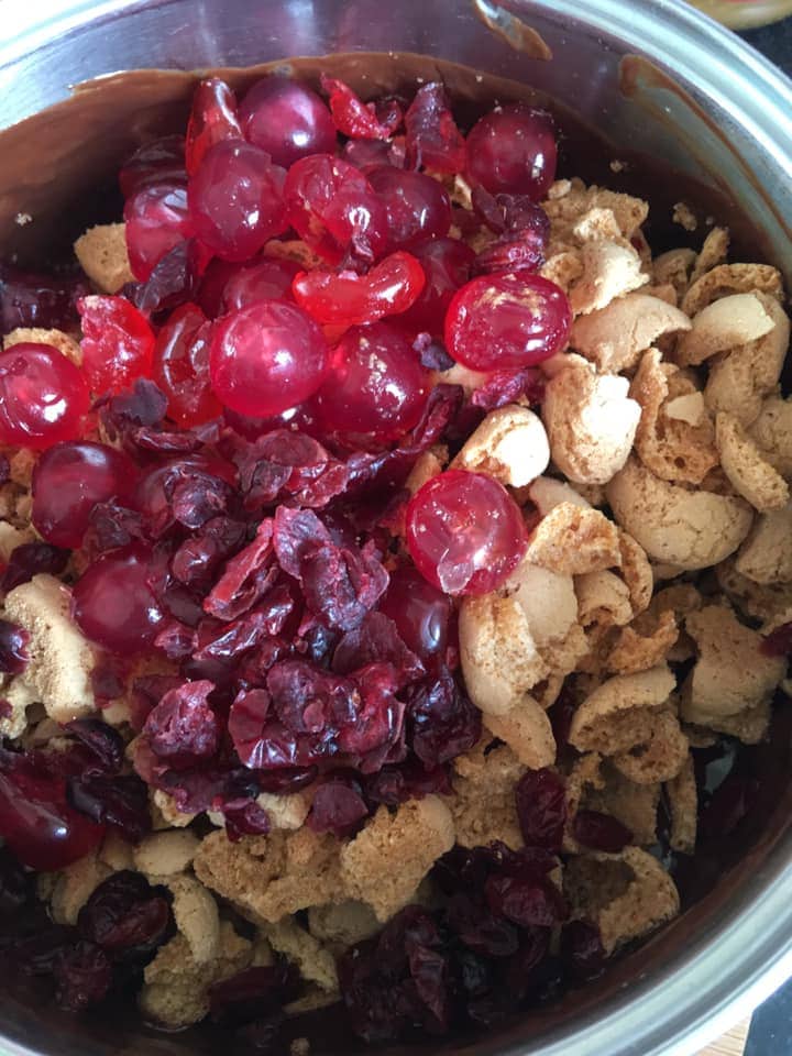 A pan of crushed amaretti biscuits, cranberries, glace cherries and chocolate