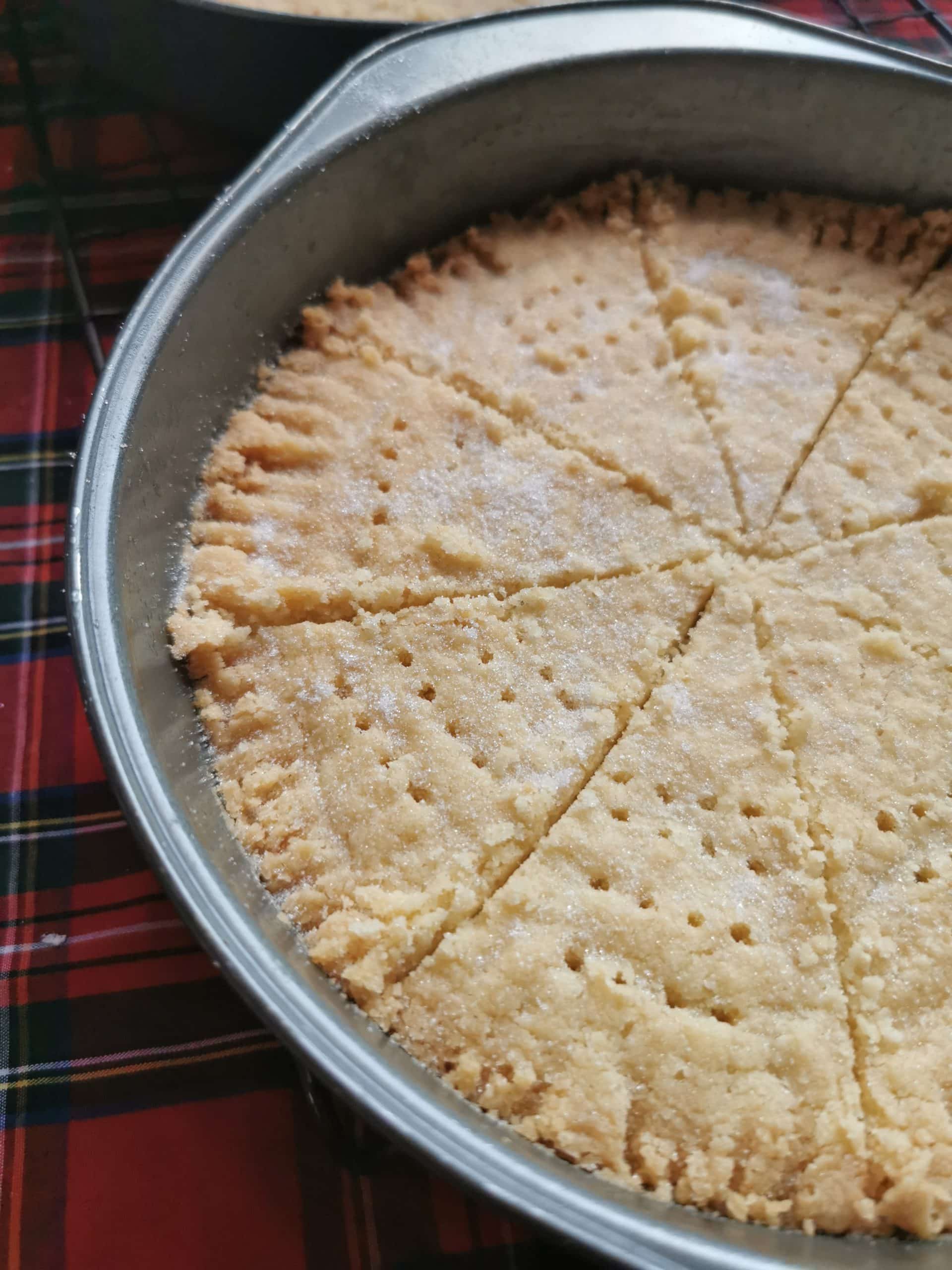 A tray of shortbread cut into triangles and sprinkled with sugar 