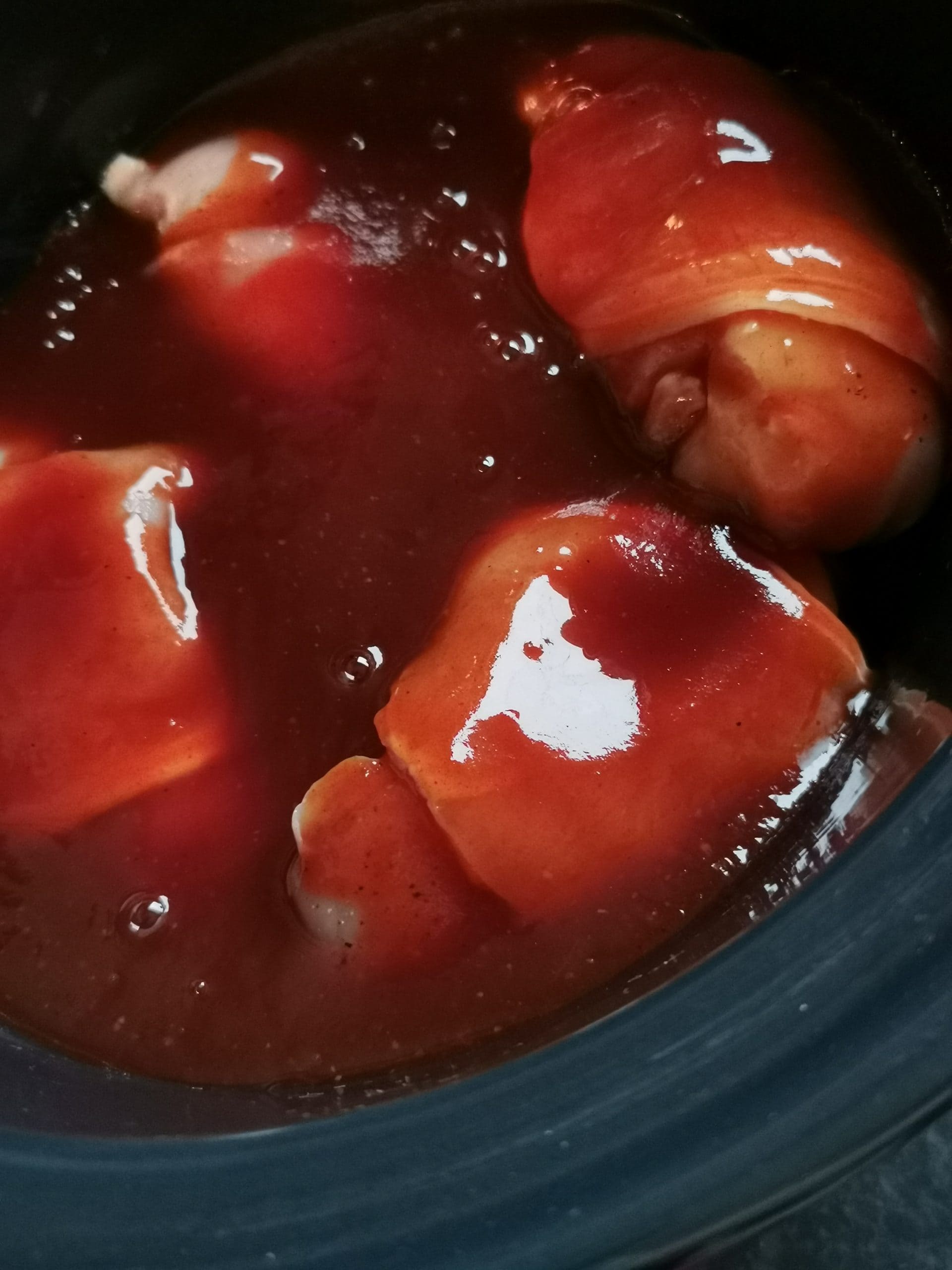 Bacon wrapped chicken fillets in bbq sauce in a slow cooker