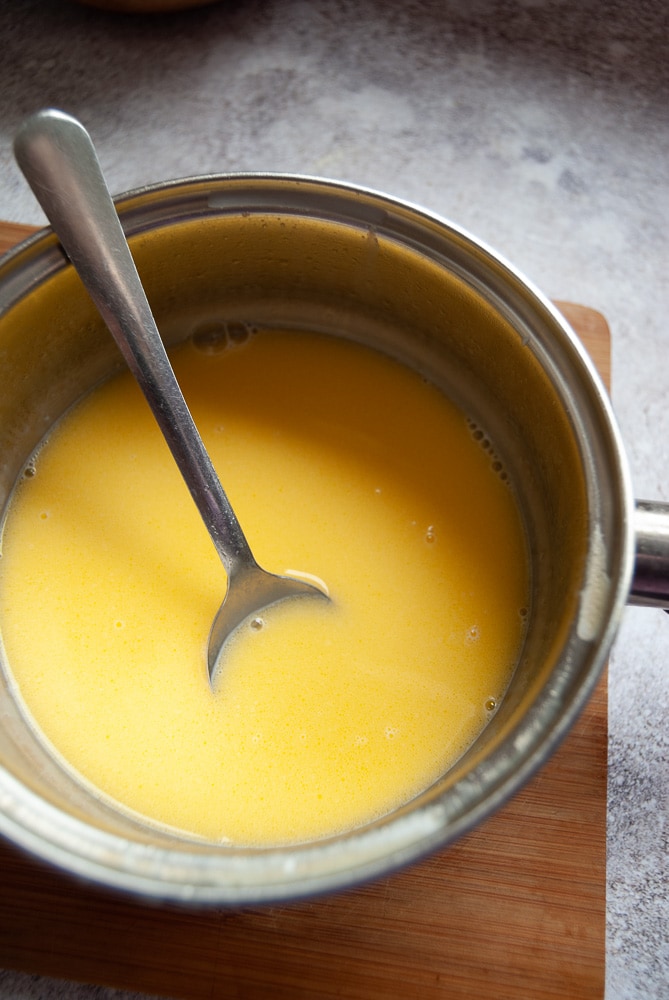 milk and melted butter in a saucepan with a silver spoon