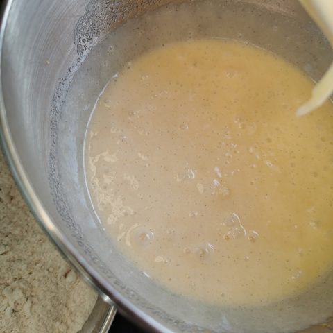 a silver bowl of beaten eggs, sugar and oil