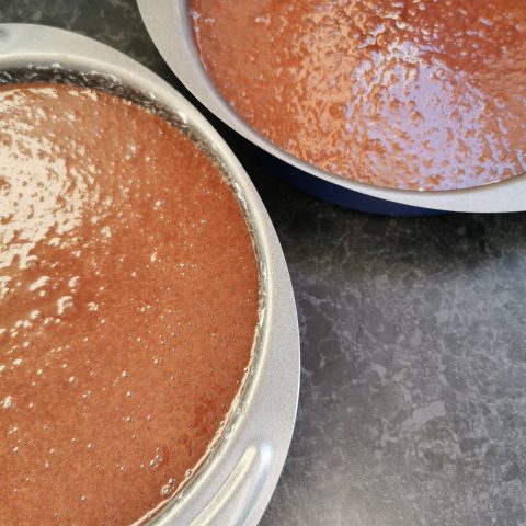 Two cake tins filled with chocolate cake batter