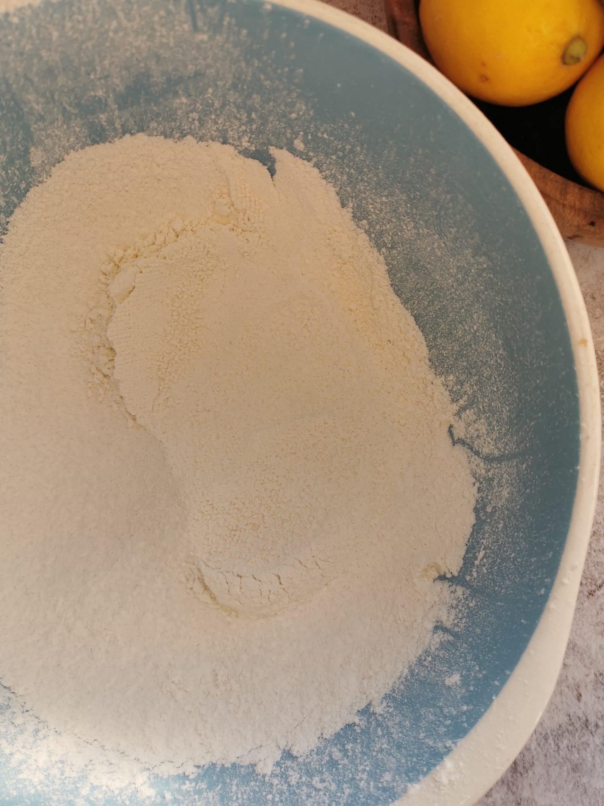 A blue and white bowl of sieved flour