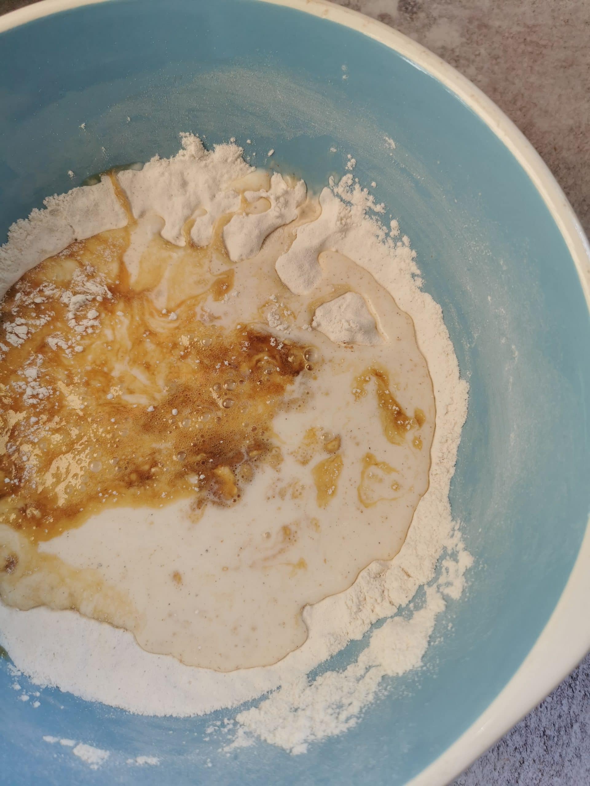 Flour, eggs and milk in a large blue and white bowl