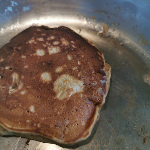 A brown sugar pancake cooking in a pan