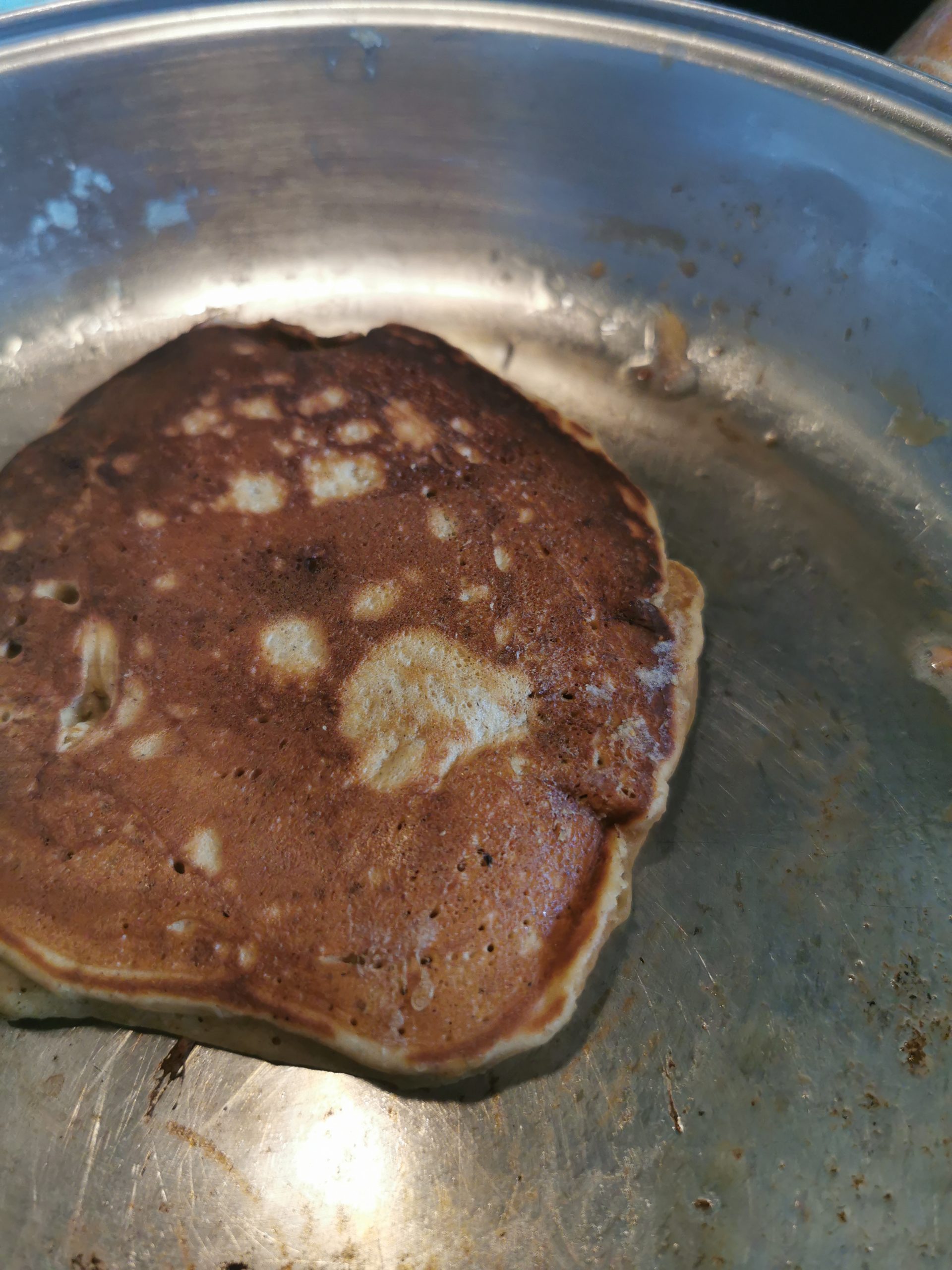 A brown sugar pancake cooking in a pan