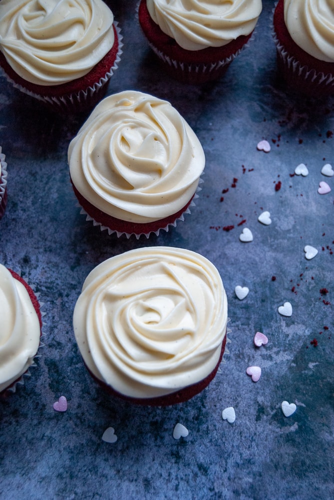 Red velvet cupcakes with cream cheese frosting on a grey background 