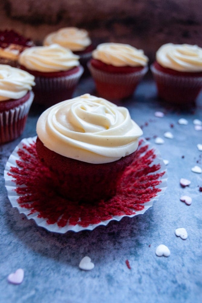 A close up picture of a red velvet cupcake with cream cheese icing