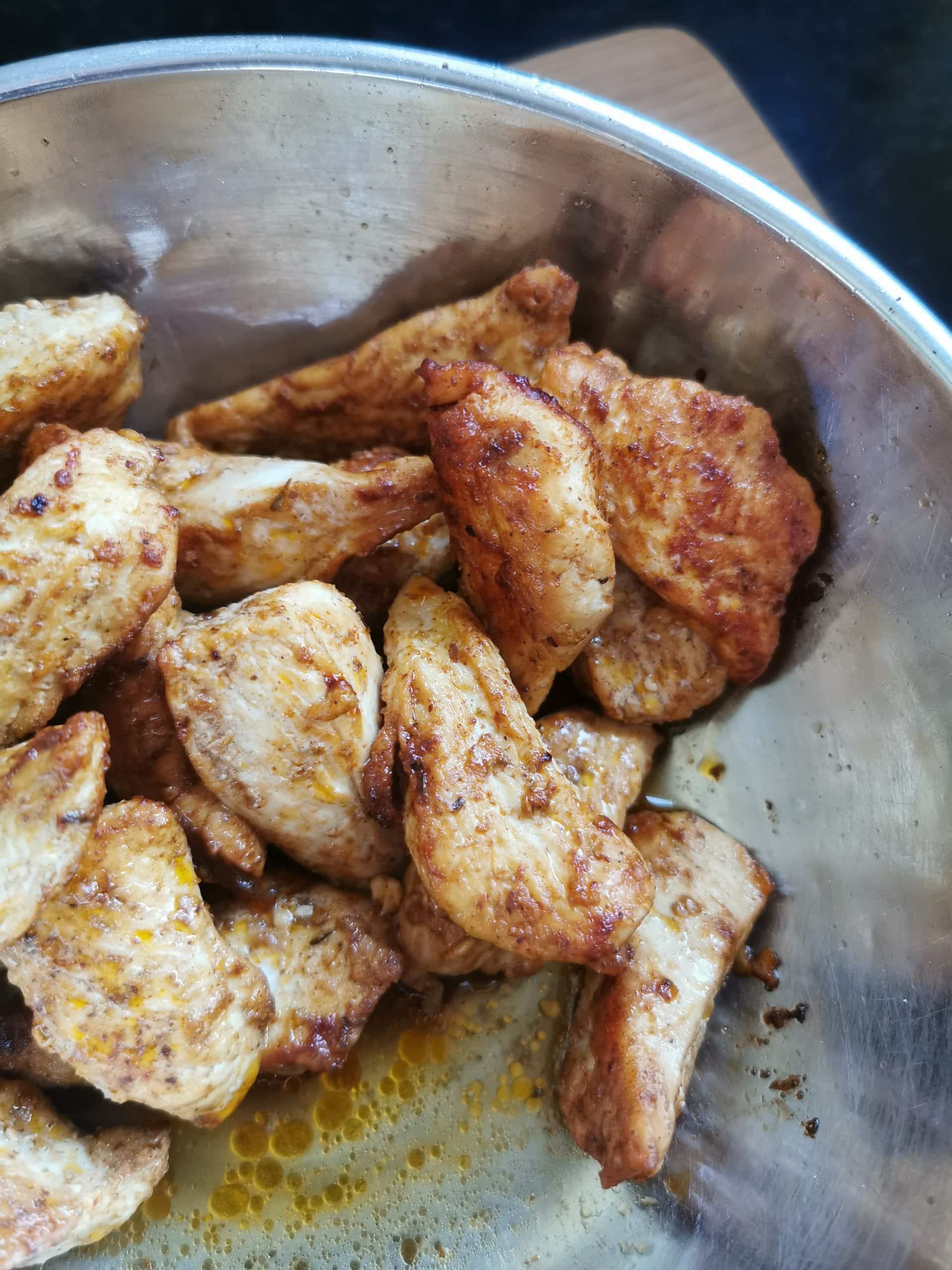 Sauteed chicken strips in a sliver bowl.