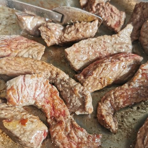 A pan of seared rump steak pieces