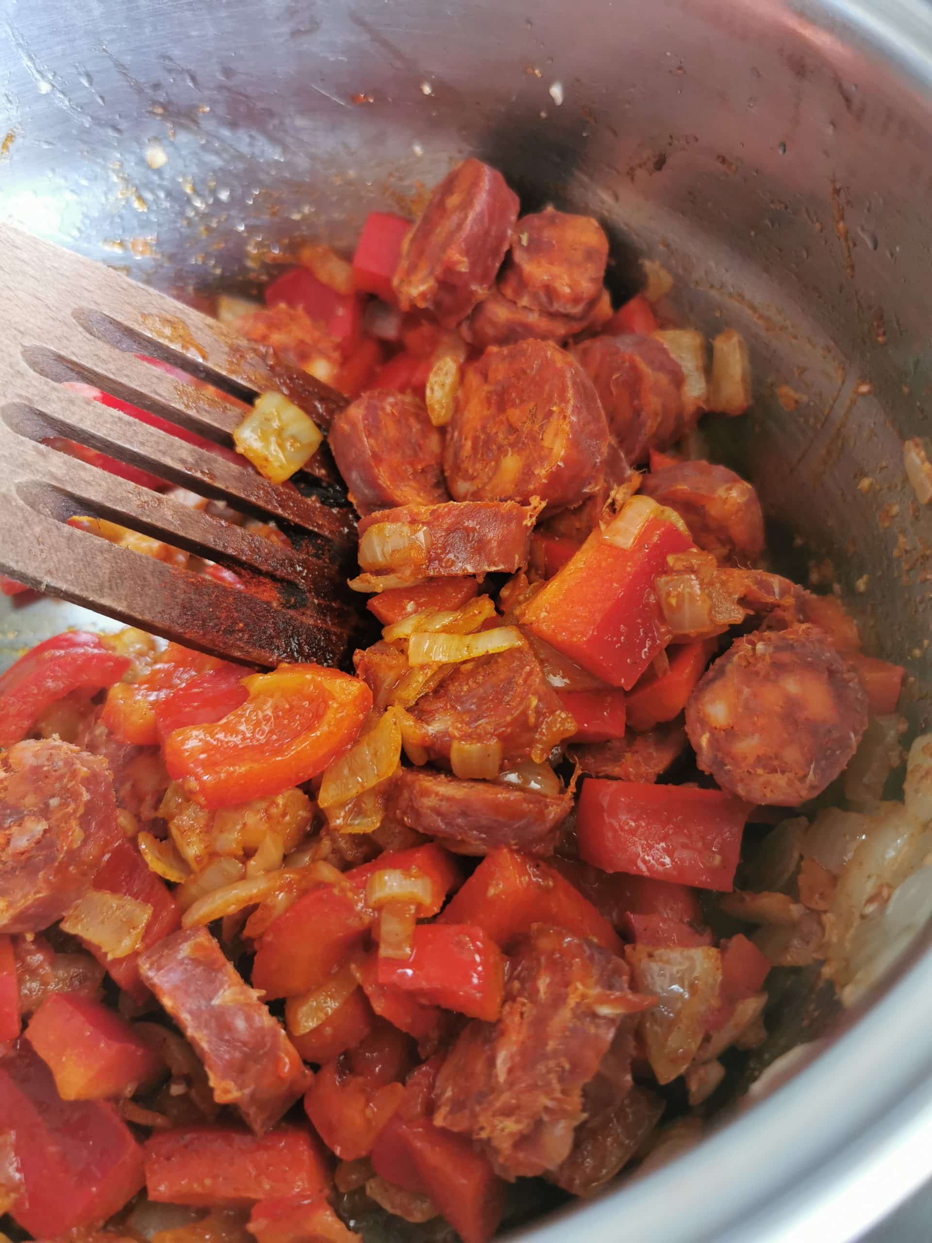 Chorizo sausage, peppers and onion cooking in a saucepan