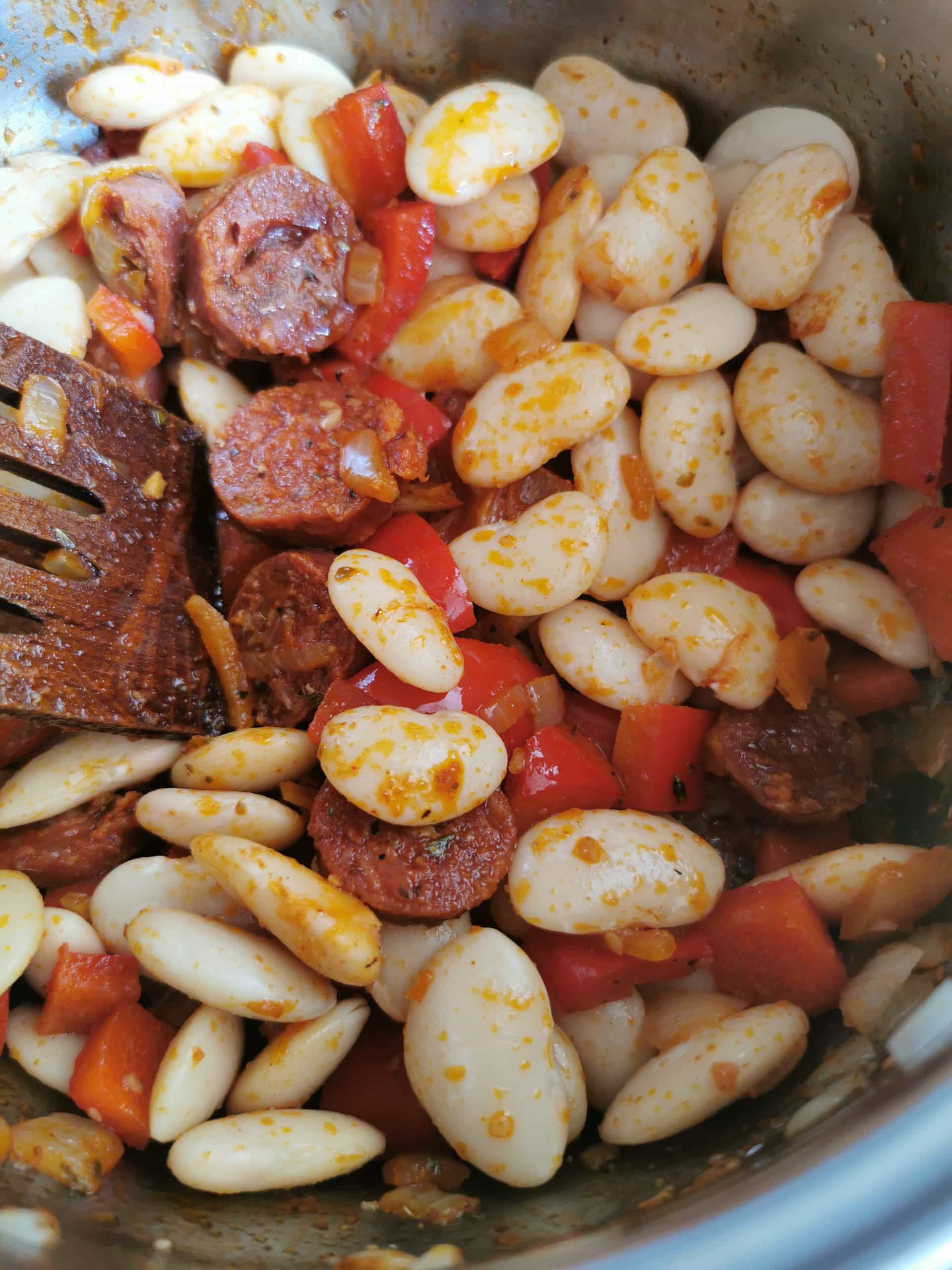 Butter beans, chorizo sausage and peppers cooking in a pan