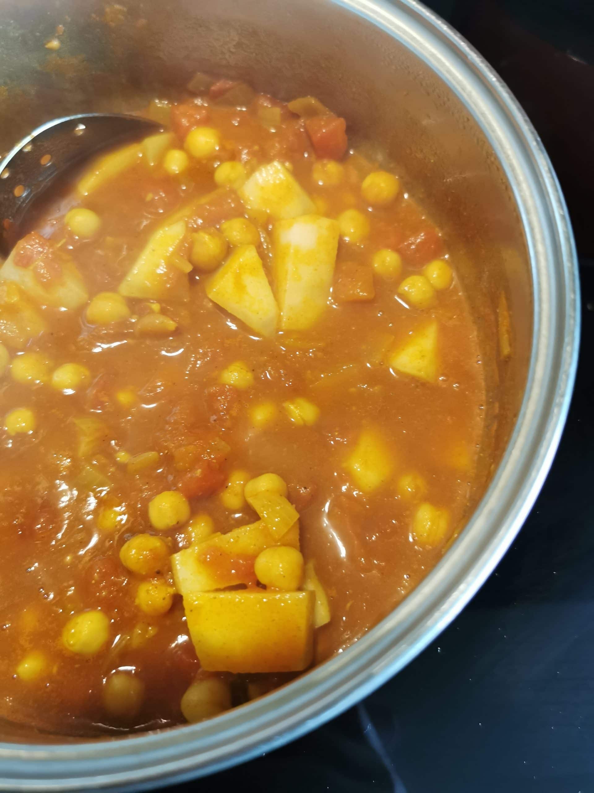 A curry with chickpeas and potatoes in a large saucepan