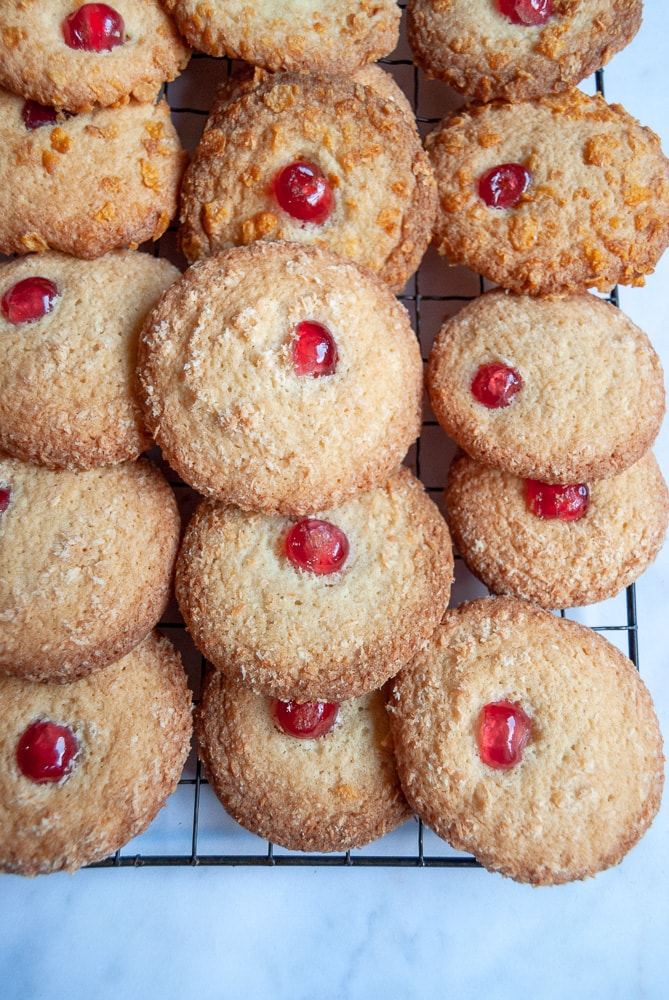 A silver wire rack with melting Moment biscuits topped with a cherry