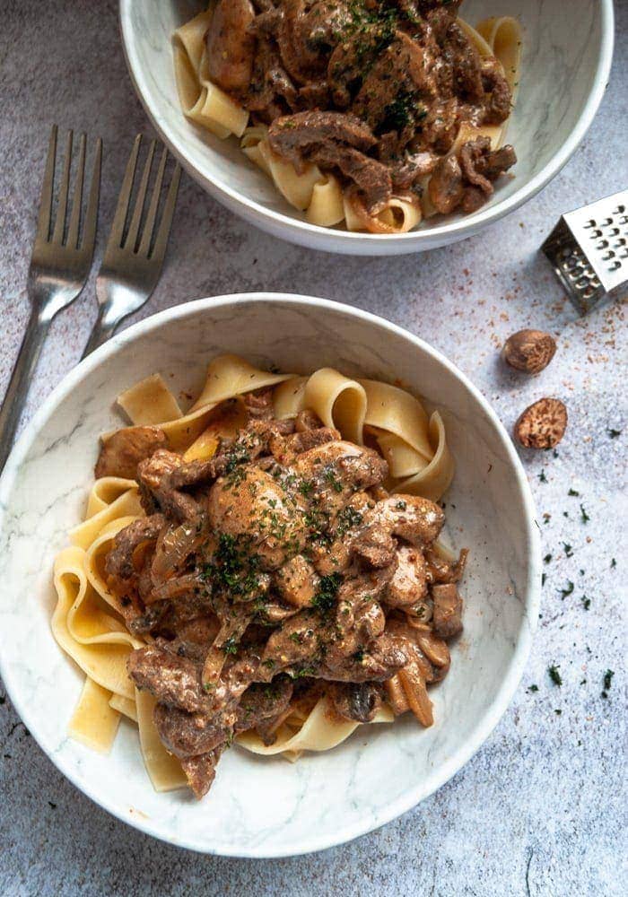 A bowl of beef stroganoff with mushrooms and egg noodles.