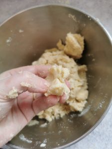A hand holding a piece of pastry dough