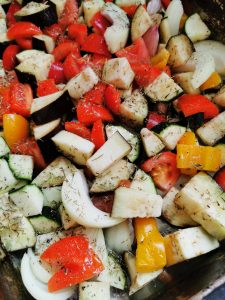 A tray of sliced aubergine, peppers, onion
