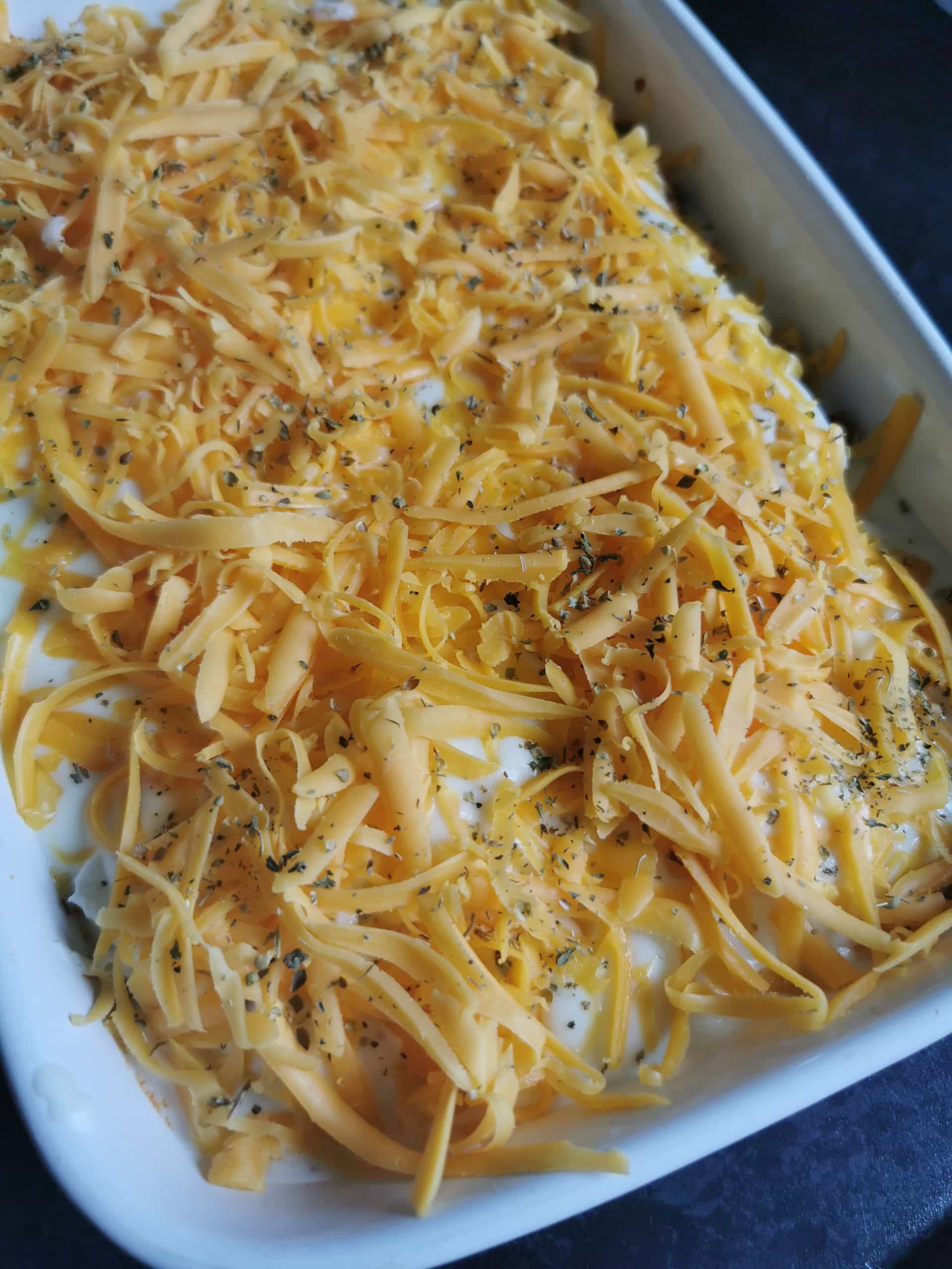 An unbaked lasagne covered with grated cheese