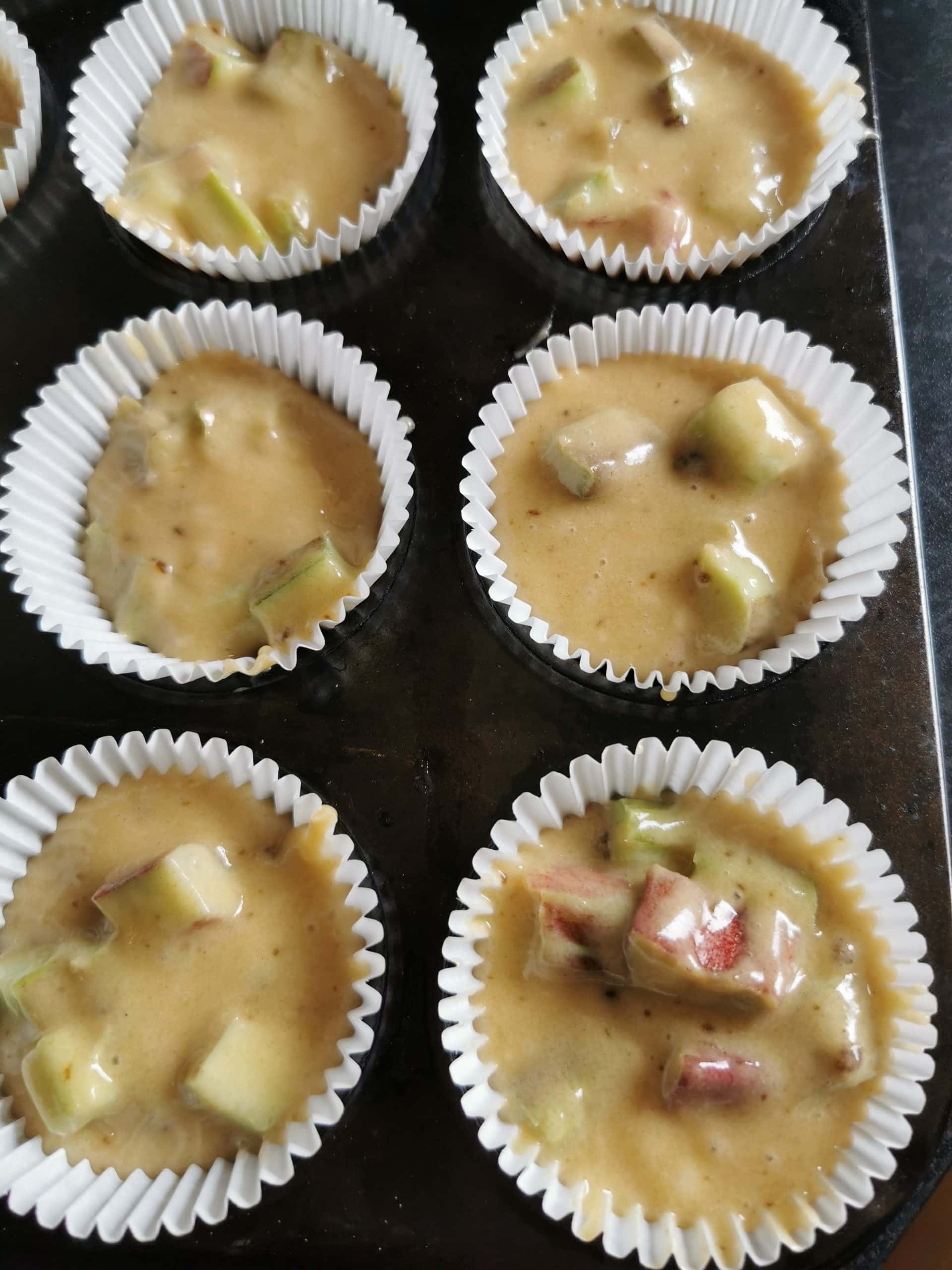 A muffin tin with unbaked rhubarb muffin batter