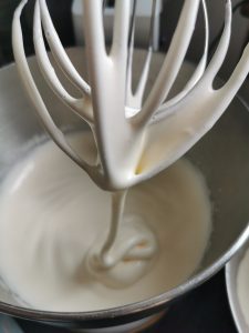 A kitchen aid mixer beating eggs and sugar together