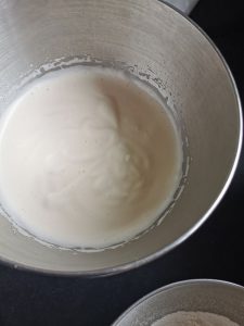 A silver mixing bowl of whisked eggs and sugar