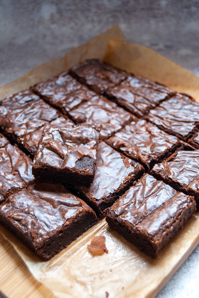 A batch of chocolate brownies on a wooden board.