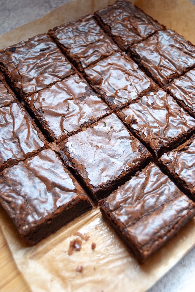 14 chocolate brownies on a wooden board