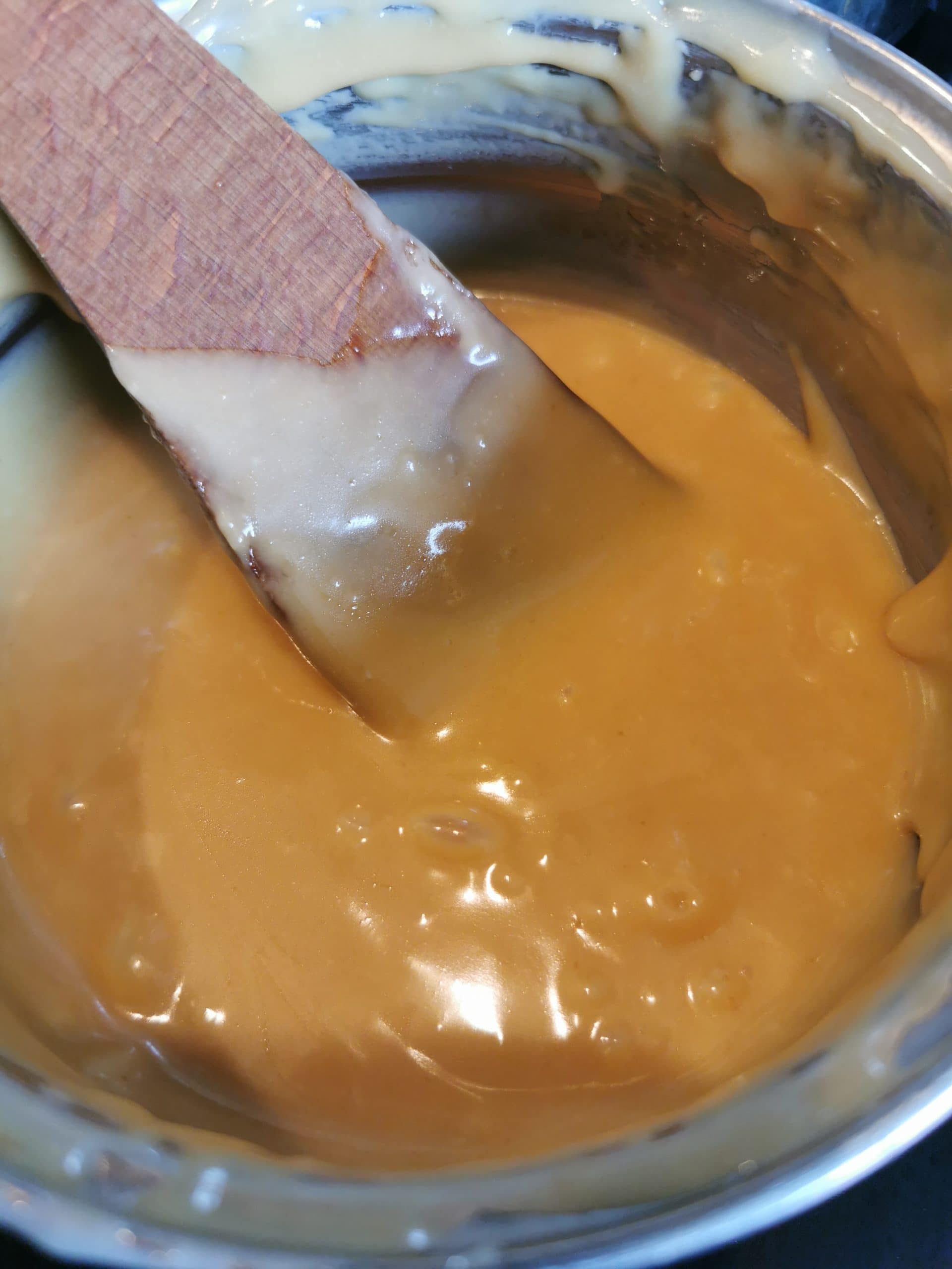 A pan of caramel and a wooden spoon