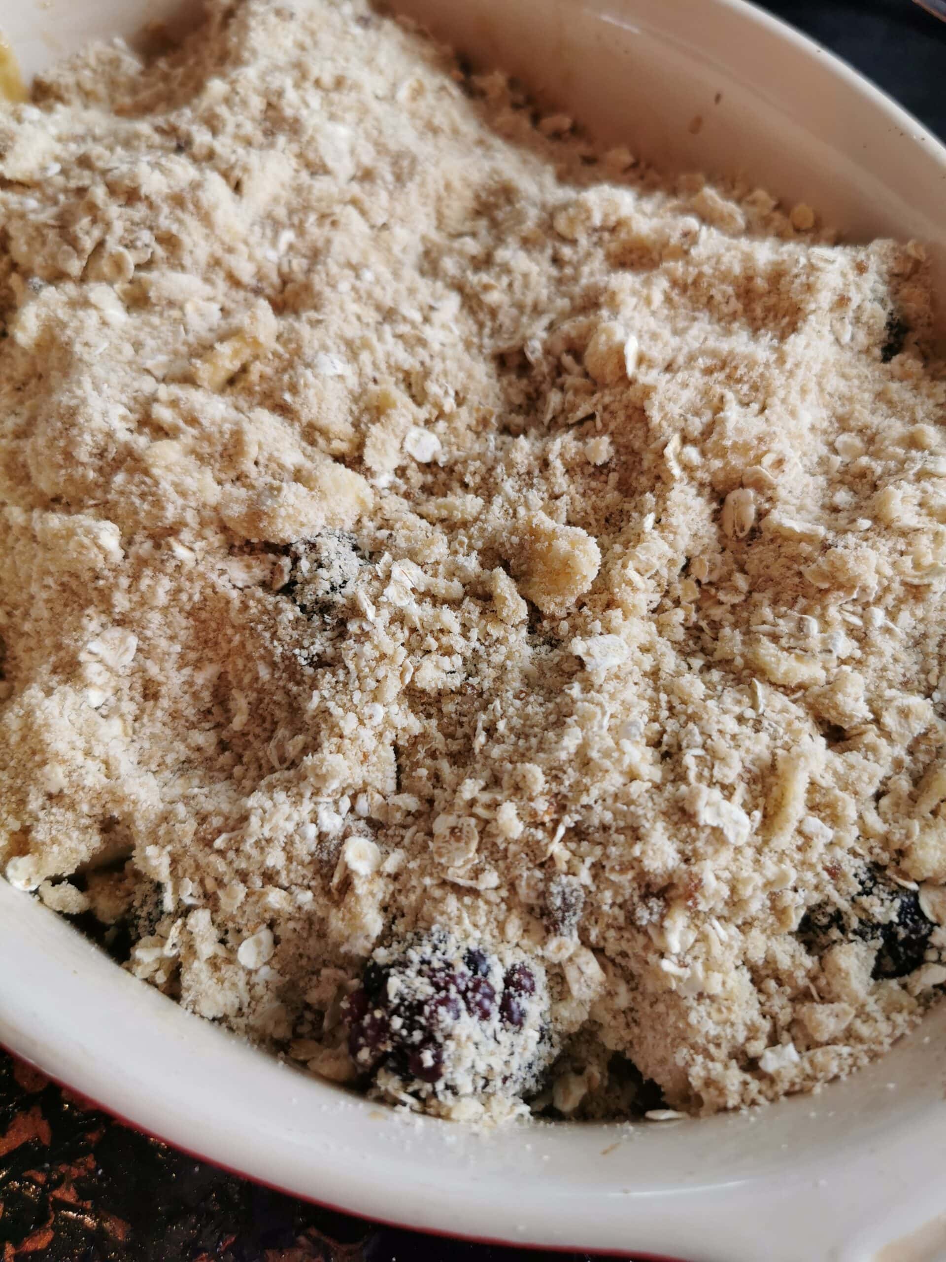 An unbaked fruit Crumble with apples and blackberries 