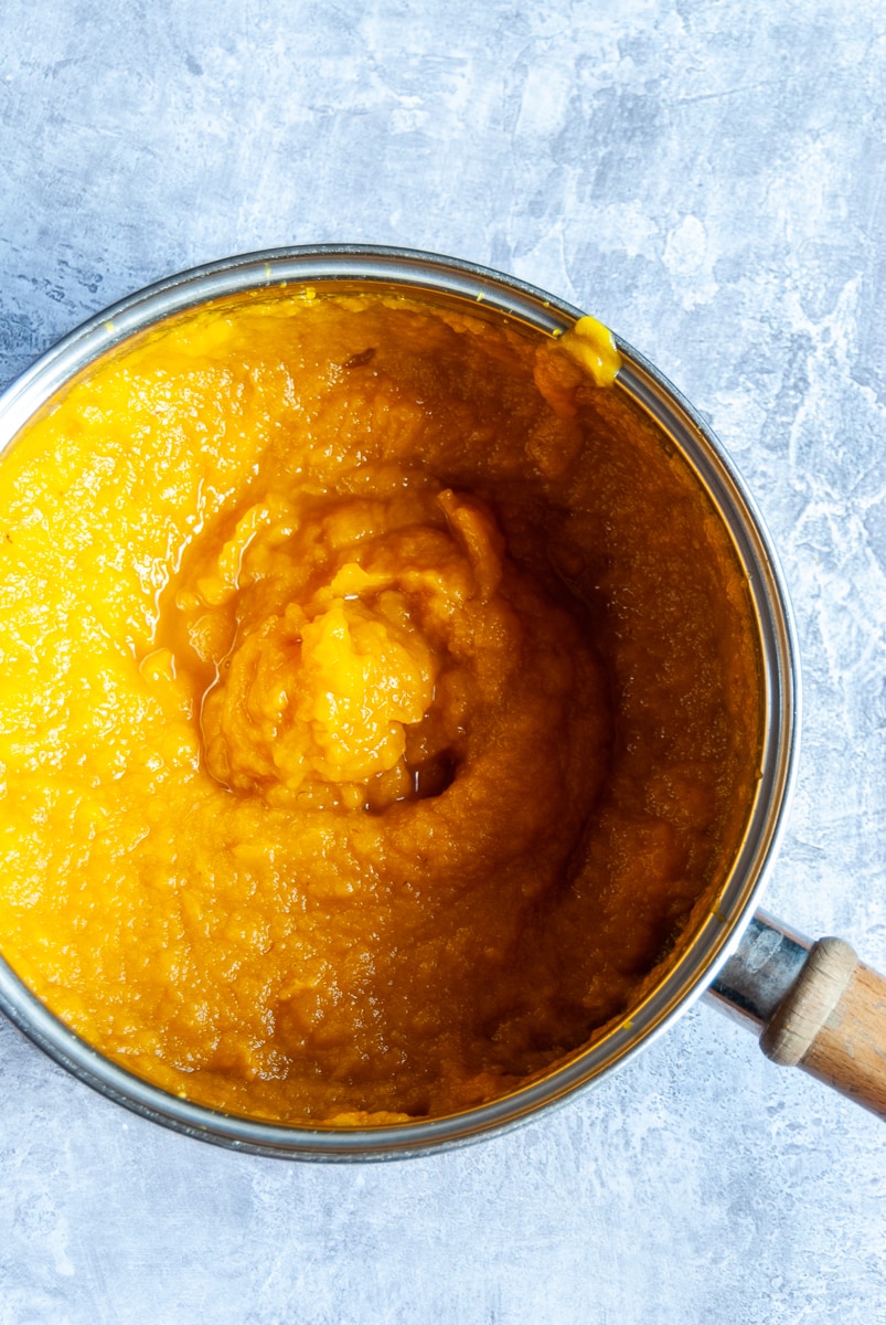 a saucepan of pureed pumpkin on a grey background