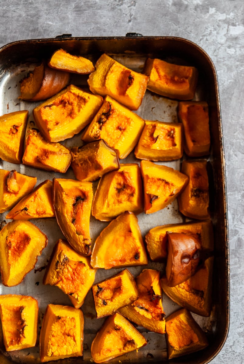 a roasting tin with roasted pumpkin cubes
