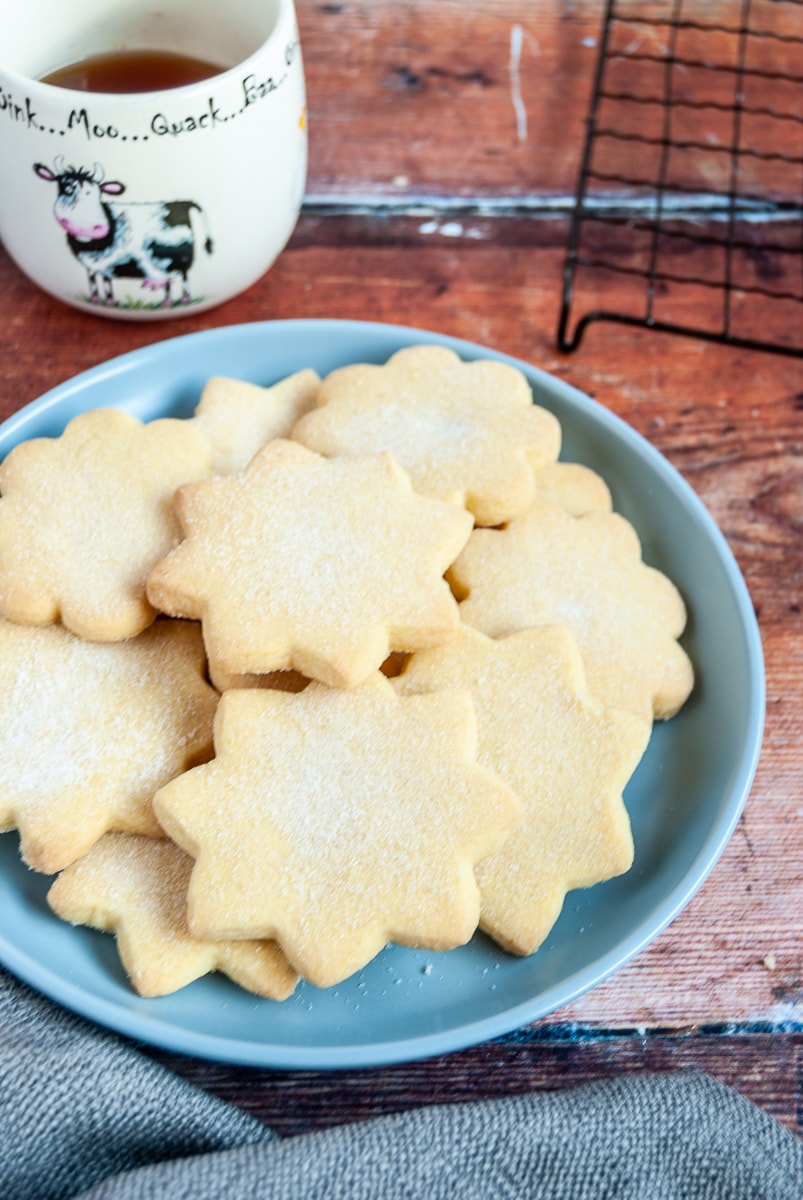 Star shaped shortbread cookies on a blue plate. 