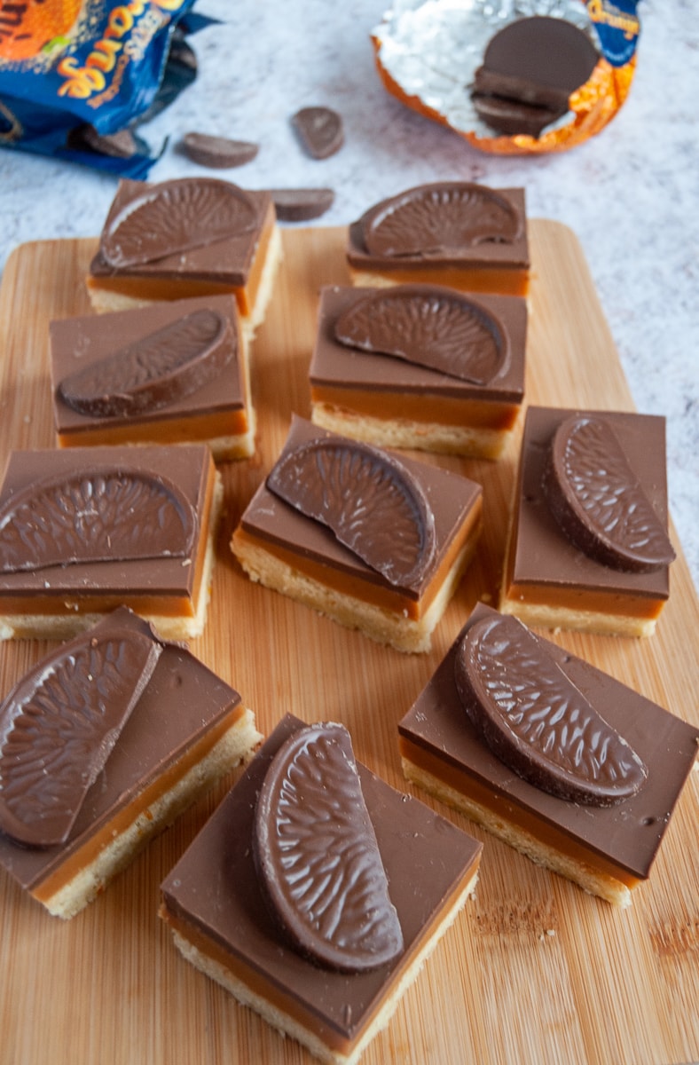 squares of chocolate orange caramel shortbread on a wooden board