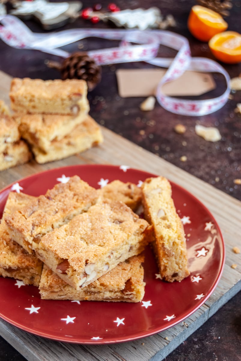 orange and almond nut bars on a red and white star plate. Christmas red and white ribbon can be seen in the background