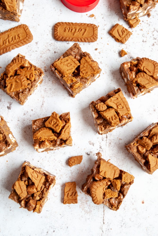 a flat lay image of rocky road squares topped with Biscoff cookies on a white backdrop 