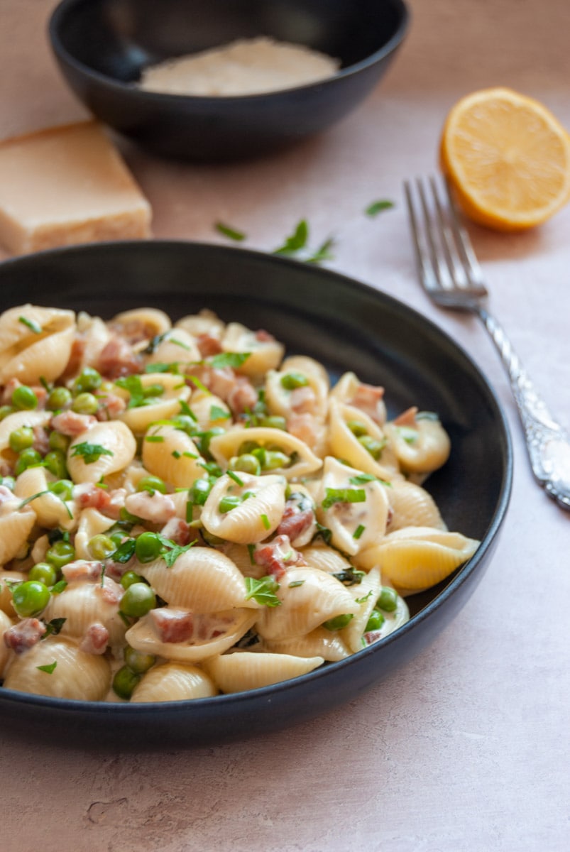  bowl of shell pasta with pancetta cubes, peas and fresh mint leaves.