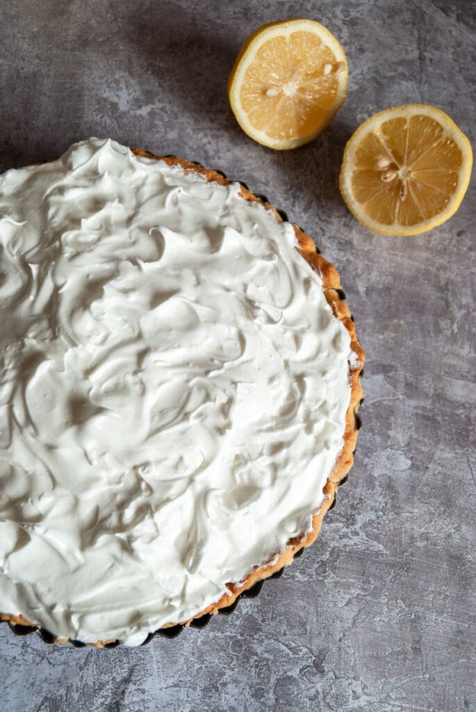 an unbaked lemon meringue pie on a grey backdrop