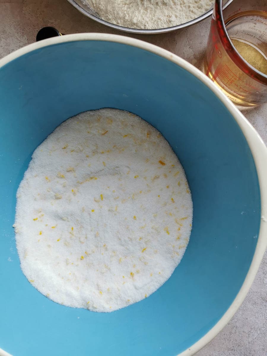 a blue and white bowl of sugar with grated lemon zest