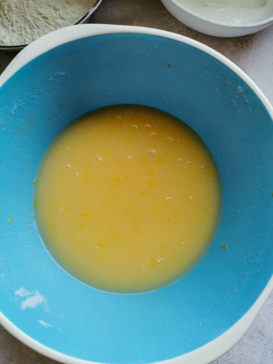 a blue and white bowl of whisked cake batter