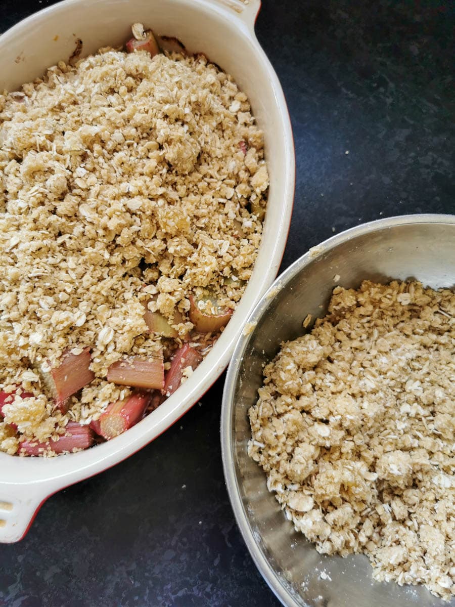 a dish of rhubarb and ginger crumble  and a silver bowl of crumble.