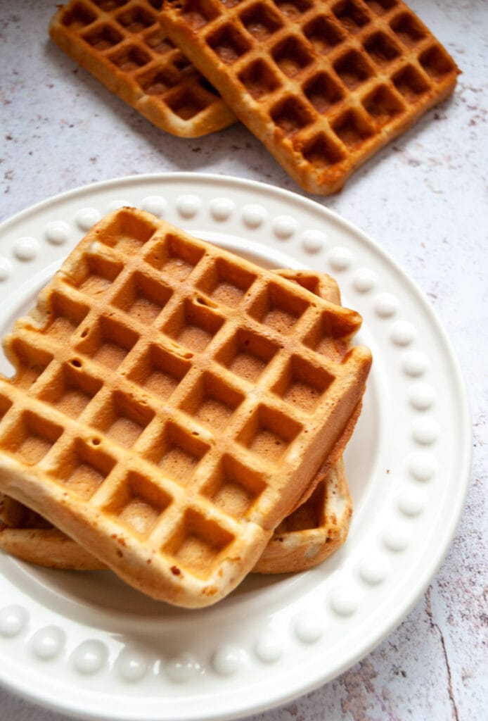 two buttermilk waffles on a white plate.