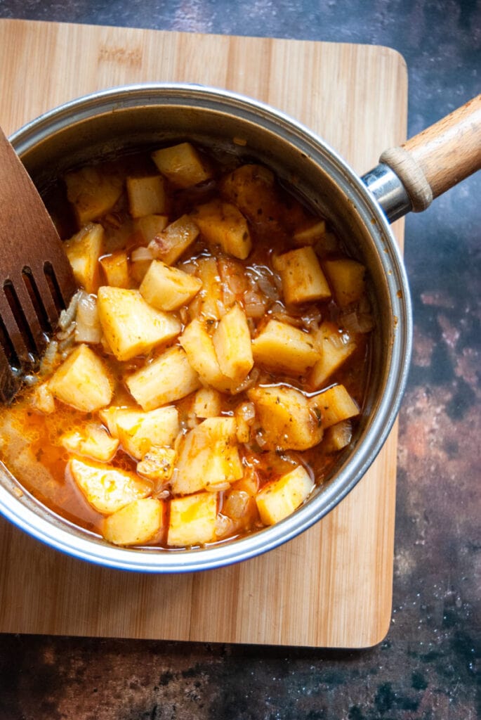 a large pan of parsnips, vegetable stock, curry paste and onions.