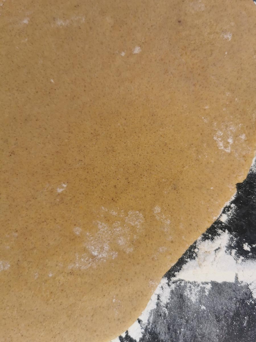 Gingerbread dough rolled out on a floured work surface.